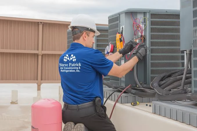 Technician measuring electrical performance at outdoor HVAC equipment
